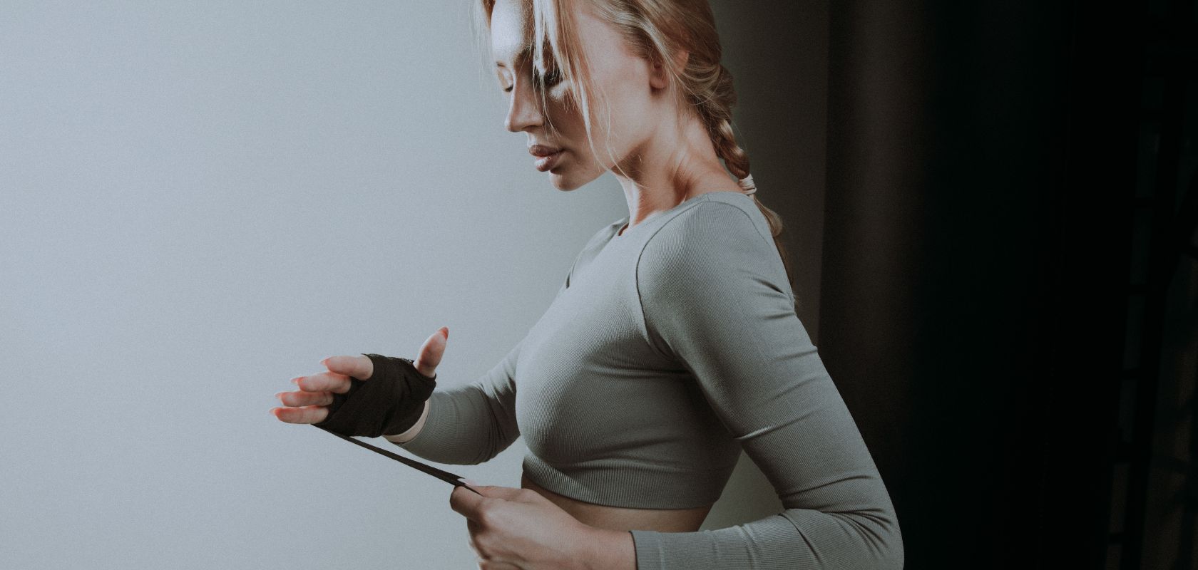 Девушка бинтует руку боксерским бинтом - фото